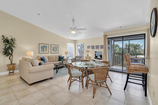 dining space with a ceiling fan, baseboards, light tile patterned flooring, and a wealth of natural light