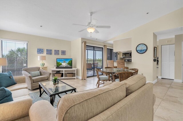 living room with baseboards, a ceiling fan, plenty of natural light, and light tile patterned floors