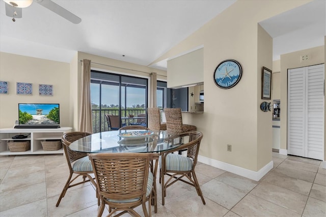 dining room with a ceiling fan, baseboards, vaulted ceiling, and light tile patterned floors