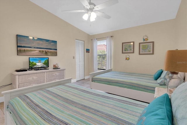 bedroom with a ceiling fan, light tile patterned floors, baseboards, a closet, and lofted ceiling