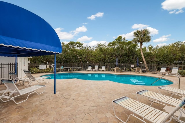 community pool featuring fence and a patio