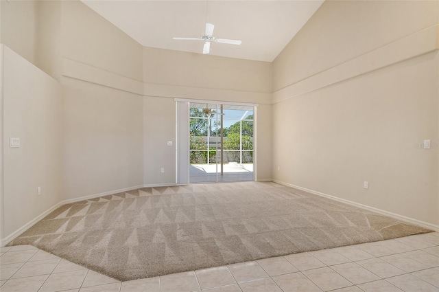 spare room with baseboards, high vaulted ceiling, light colored carpet, and a ceiling fan