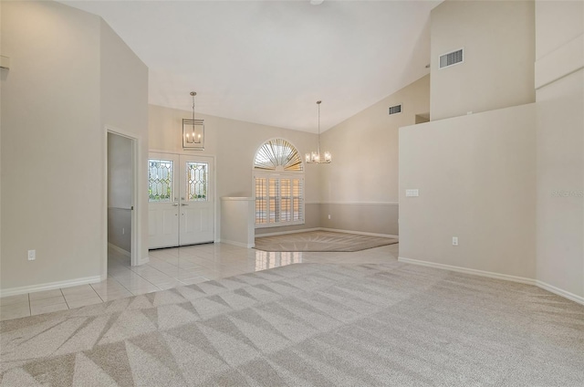 unfurnished room with visible vents, baseboards, high vaulted ceiling, and a notable chandelier