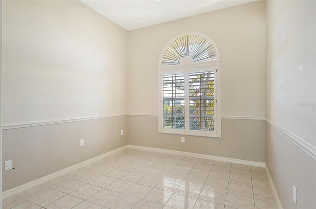 unfurnished room with light tile patterned flooring and baseboards