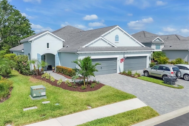 2628 Sapphire Blue Ln, Bradenton, FL 34211 - traditional-style home featuring a garage, decorative driveway, a front yard, stucco siding, and a tiled roof