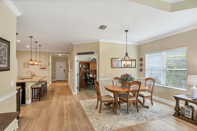 2628 Sapphire Blue Ln, Bradenton, FL 34211 - dining space with light wood finished floors, baseboards, recessed lighting, crown molding, and a chandelier
