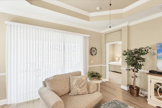 2628 Sapphire Blue Ln, Bradenton, FL 34211 - living area featuring wood finished floors, ornamental molding, a tray ceiling, and baseboards
