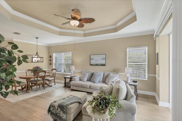 2628 Sapphire Blue Ln, Bradenton, FL 34211 - living area featuring a tray ceiling, light wood-style floors, plenty of natural light, ceiling fan, and crown molding