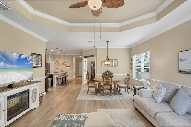 2628 Sapphire Blue Ln, Bradenton, FL 34211 - living area with a raised ceiling, light wood-type flooring, ceiling fan, ornamental molding, and baseboards