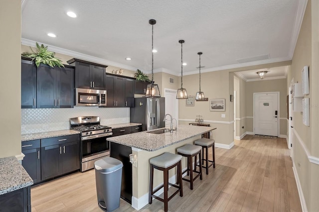 2628 Sapphire Blue Ln, Bradenton, FL 34211 - kitchen with stainless steel appliances, a sink, a kitchen bar, backsplash, and a kitchen island with sink
