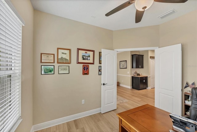 2628 Sapphire Blue Ln, Bradenton, FL 34211 - home office featuring a ceiling fan, light wood-style floors, and baseboards