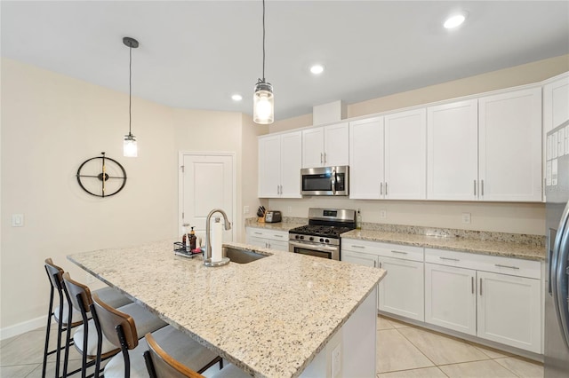 5406 Coral Reef Way, Lakewood Ranch, FL 34211 - kitchen featuring appliances with stainless steel finishes, a sink, white cabinetry, a center island with sink, and light tile patterned flooring