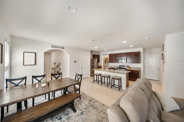dining area with arched walkways and recessed lighting
