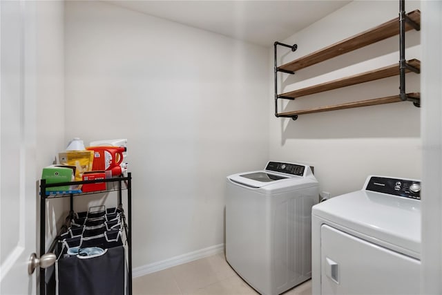 laundry area featuring separate washer and dryer, light tile patterned flooring, baseboards, and laundry area