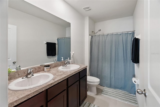 bathroom with double vanity, visible vents, a sink, and toilet
