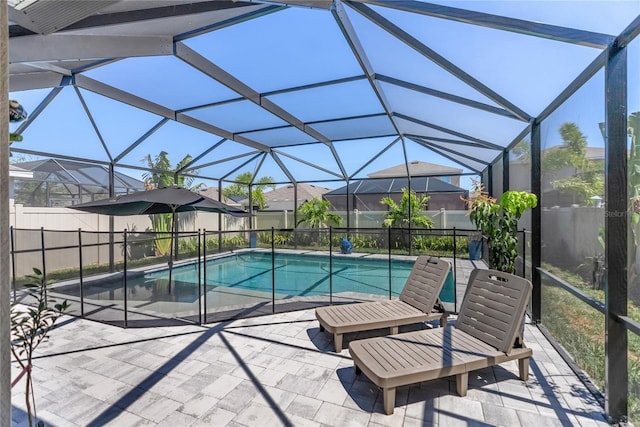 view of pool featuring glass enclosure, fence, a patio, and a fenced in pool