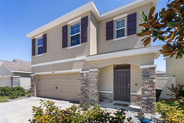 view of front of home with stone siding, concrete driveway, stucco siding, and an attached garage
