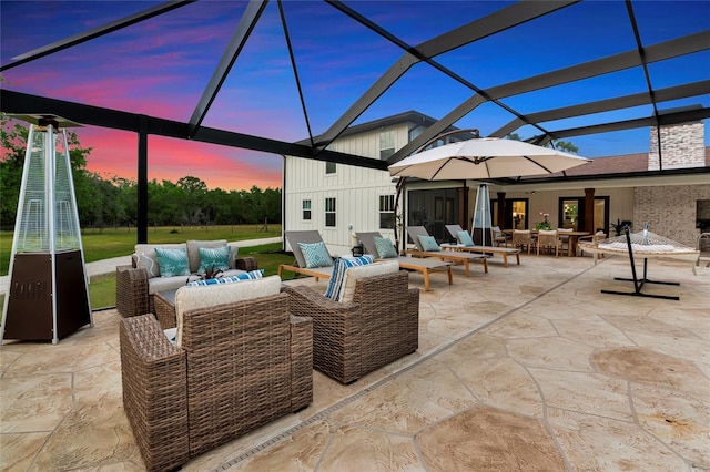 1208 Oak Hammock Rd, Sarasota, FL 34240 - patio terrace at dusk featuring an outdoor living space, glass enclosure, and outdoor dining space