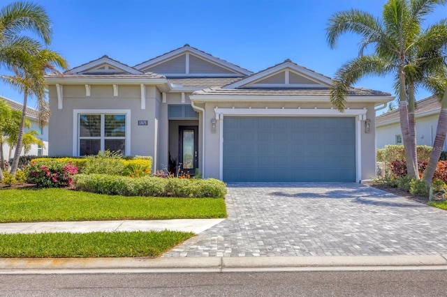 17675 Azul Dr, Lakewood Ranch, FL 34202 - view of front of property with a tiled roof, an attached garage, decorative driveway, and stucco siding