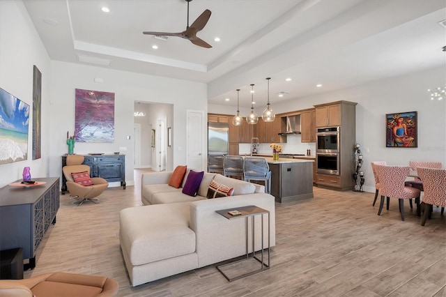 17675 Azul Dr, Lakewood Ranch, FL 34202 - living room featuring light wood-style flooring, ceiling fan, a raised ceiling, and recessed lighting