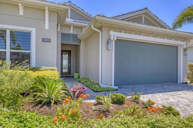 17675 Azul Dr, Lakewood Ranch, FL 34202 - view of front of house with an attached garage, decorative driveway, and stucco siding