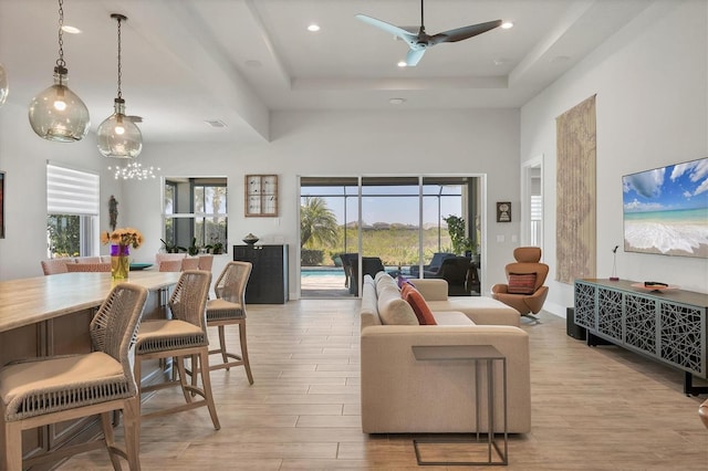 17675 Azul Dr, Lakewood Ranch, FL 34202 - living room with a towering ceiling, recessed lighting, a raised ceiling, light wood finished floors, and ceiling fan
