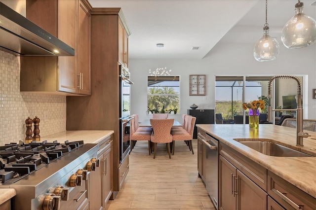 17675 Azul Dr, Lakewood Ranch, FL 34202 - kitchen with light wood-style flooring, decorative backsplash, stainless steel appliances, range hood, and a sink