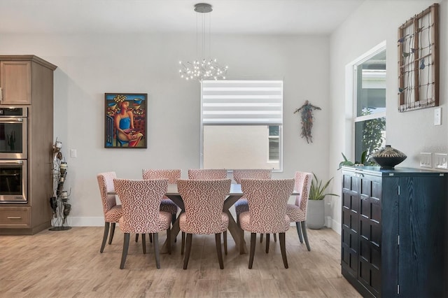 17675 Azul Dr, Lakewood Ranch, FL 34202 - dining area featuring light wood finished floors, baseboards, and an inviting chandelier