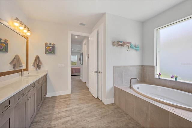17675 Azul Dr, Lakewood Ranch, FL 34202 - full bath featuring vanity, connected bathroom, visible vents, a bath, and wood finished floors