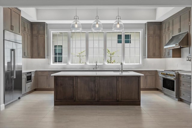 9241 Starry Night Ave, Sarasota, FL 34241 - kitchen with light countertops, tasteful backsplash, under cabinet range hood, an island with sink, and high quality appliances