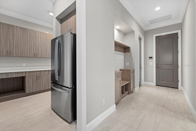 9241 Starry Night Ave, Sarasota, FL 34241 - kitchen with light countertops, crown molding, baseboards, modern cabinets, and freestanding refrigerator