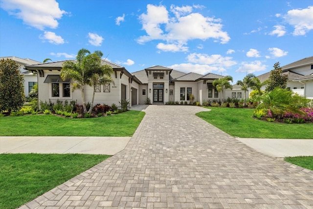 9241 Starry Night Ave, Sarasota, FL 34241 - view of front of home with a front yard, french doors, stucco siding, an attached garage, and decorative driveway