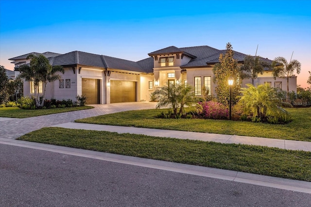 9241 Starry Night Ave, Sarasota, FL 34241 - view of front of property with a tile roof, stucco siding, an attached garage, a front lawn, and decorative driveway
