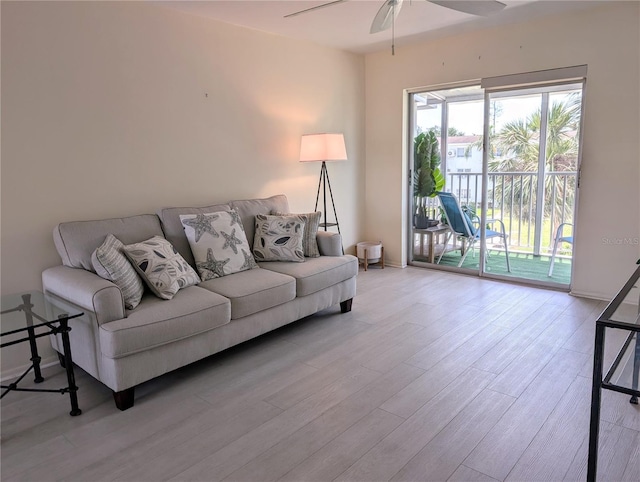 living room featuring wood finished floors, baseboards, and a ceiling fan