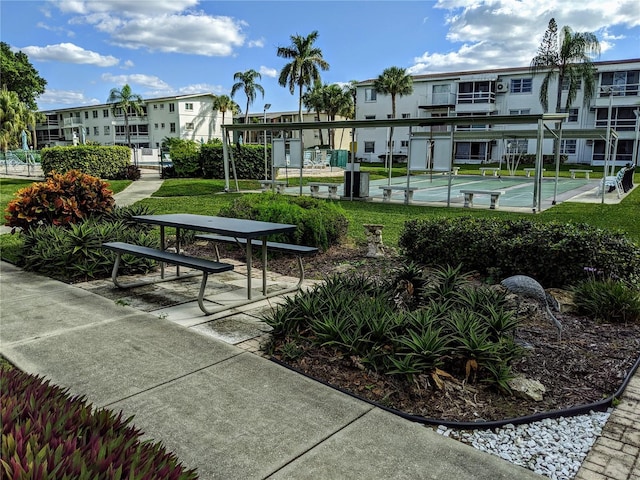 view of home's community with a lawn, a residential view, and shuffleboard