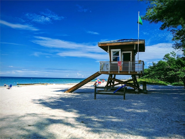 exterior space with a water view and a view of the beach