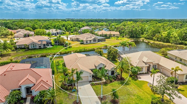 birds eye view of property with a residential view, a water view, and a view of trees