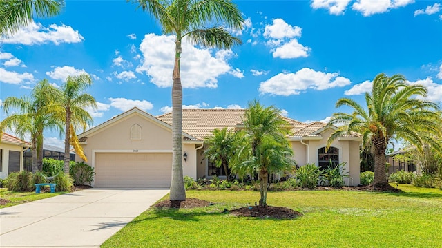 view of front of house with concrete driveway, stucco siding, an attached garage, a tiled roof, and a front yard