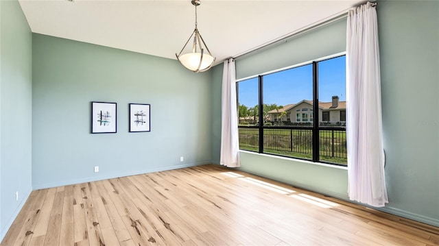 unfurnished room featuring baseboards and wood finished floors