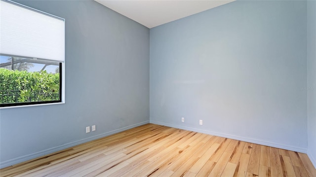 spare room featuring baseboards and wood finished floors