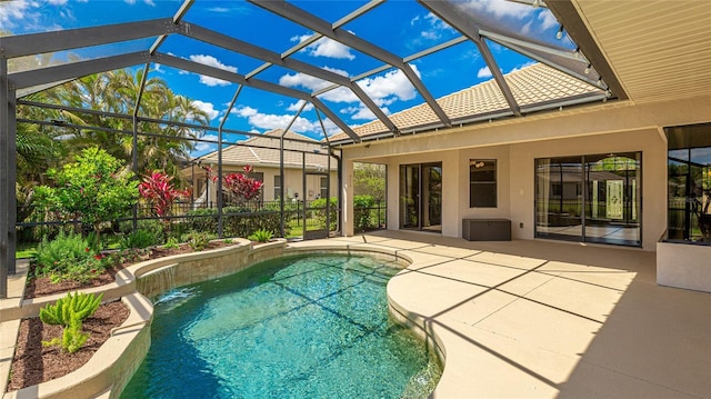 outdoor pool with glass enclosure and a patio