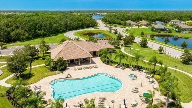 community pool featuring fence, a gazebo, a water view, and a patio