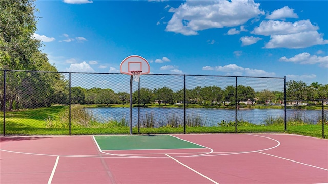 view of basketball court with a water view, fence, and community basketball court
