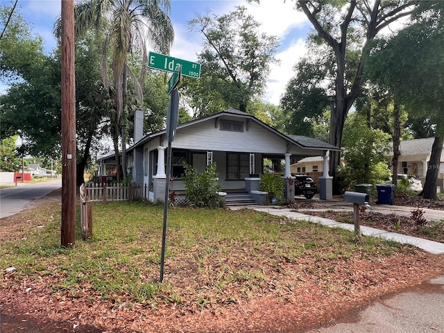 1002 E Ida St, Tampa, FL 33603 - view of front facade featuring a chimney, a front lawn, and a porch