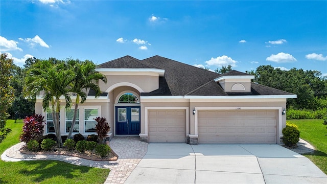 12841 Balsam Ter, Bradenton, FL 34212 - view of front facade with stucco siding, an attached garage, driveway, and french doors