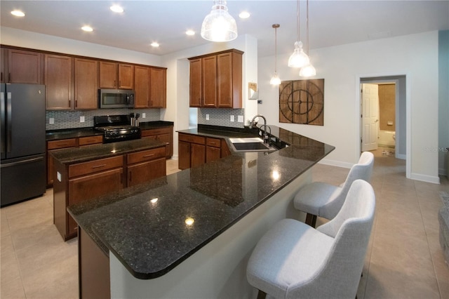12841 Balsam Ter, Bradenton, FL 34212 - kitchen featuring black appliances, a sink, decorative backsplash, light tile patterned floors, and a center island
