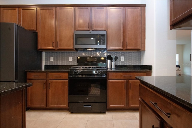 12841 Balsam Ter, Bradenton, FL 34212 - kitchen with stainless steel appliances, backsplash, dark stone counters, and light tile patterned floors