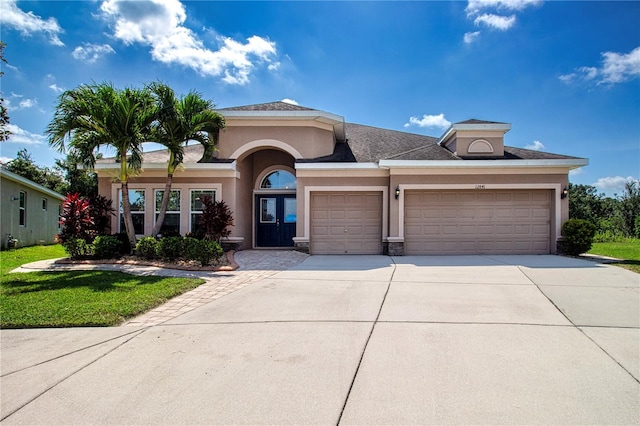 12841 Balsam Ter, Bradenton, FL 34212 - view of front of home with an attached garage, stucco siding, concrete driveway, and a front lawn