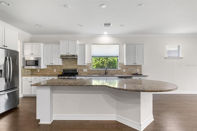 kitchen featuring under cabinet range hood, visible vents, dark wood finished floors, stainless steel appliances, and a sink