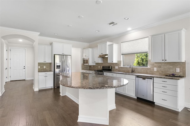 kitchen with dark wood-type flooring, a sink, visible vents, and stainless steel appliances